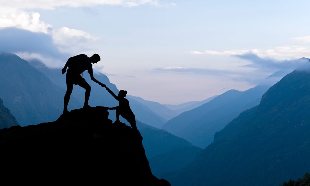 teamwork-couple-climbing-helping-hand